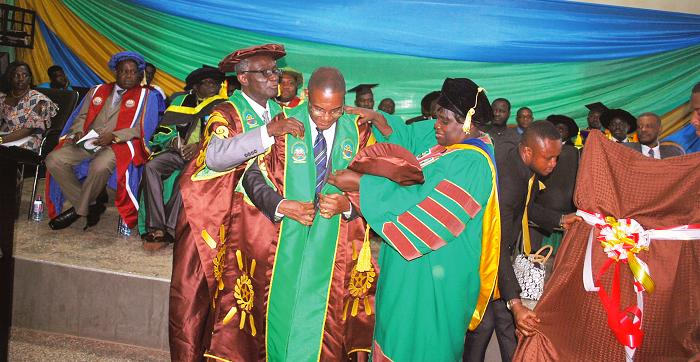 Prof. Ayim (left) and Prof. Esi Awuah (right) decorating the new Vice-Chancellor, Prof. Dapaah, with his academic robe after the swearing-in. INSET:  the new vice chancellor delivering his maiden address